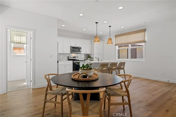 a living room with furniture a flat screen tv and kitchen view