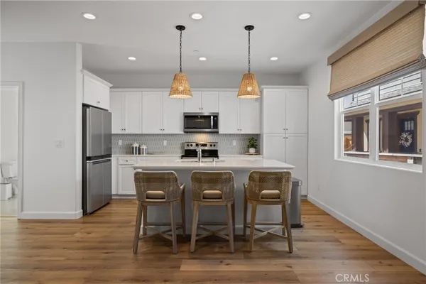 a kitchen with a table chairs microwave and cabinets