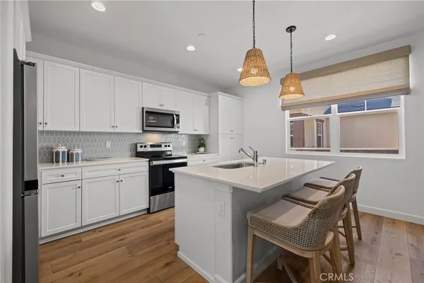 a kitchen with cabinets a center island and appliances