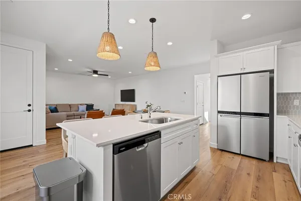 a kitchen with a sink dishwasher and a dining table with wooden floor
