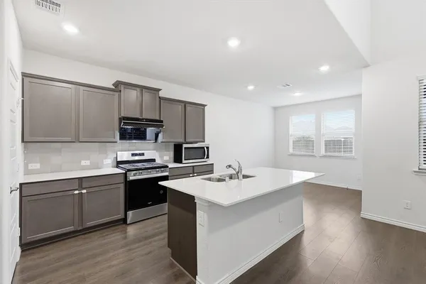 a kitchen with appliances a sink and cabinets