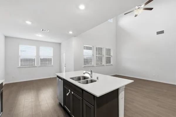 a kitchen with a sink cabinets and wooden floor