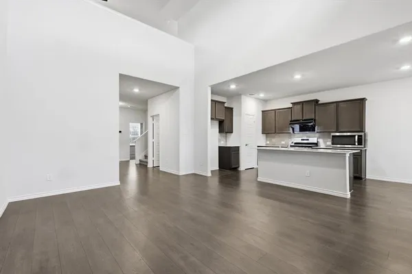 a view of kitchen with granite countertop stainless steel appliances refrigerator sink and microwave