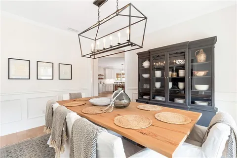 a kitchen with stainless steel appliances kitchen island granite countertop a table chairs and a sink