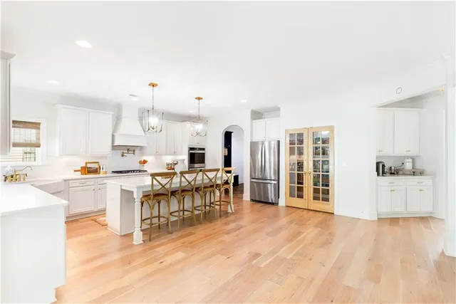 a large white kitchen with lots of counter space and stainless steel appliances