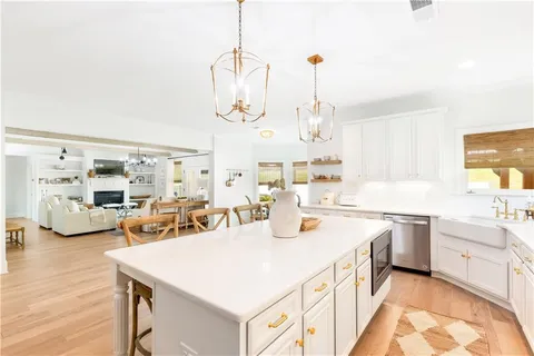 a kitchen with stainless steel appliances a stove a sink a chimney and a center island