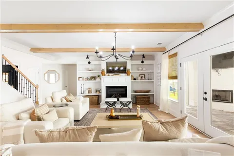 a living room with fireplace furniture and a view of kitchen