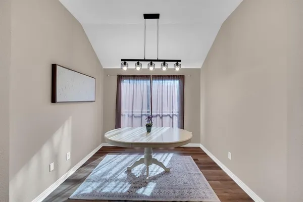 a view of a dining room with a table and chairs
