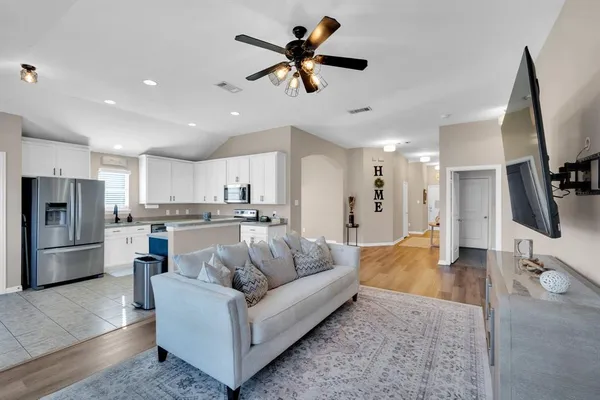 a living room with stainless steel appliances kitchen island furniture and a view of kitchen