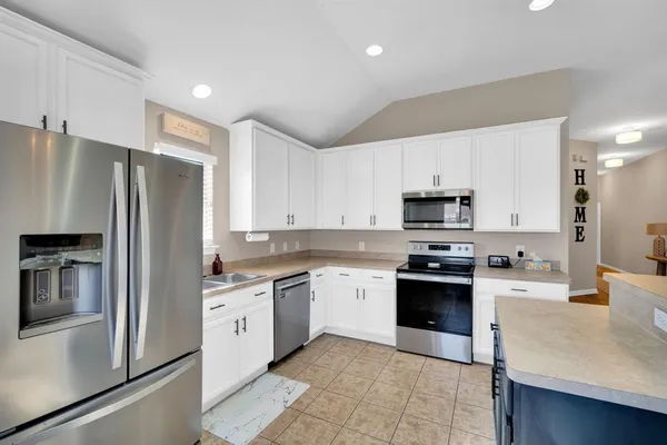 a kitchen with stainless steel appliances granite countertop a refrigerator sink and stove
