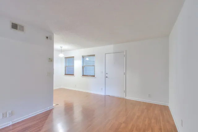 a view of an empty room and wooden floor