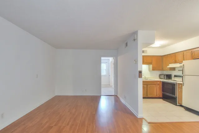 a view of a kitchen with a stove wooden cabinets and a refrigerator