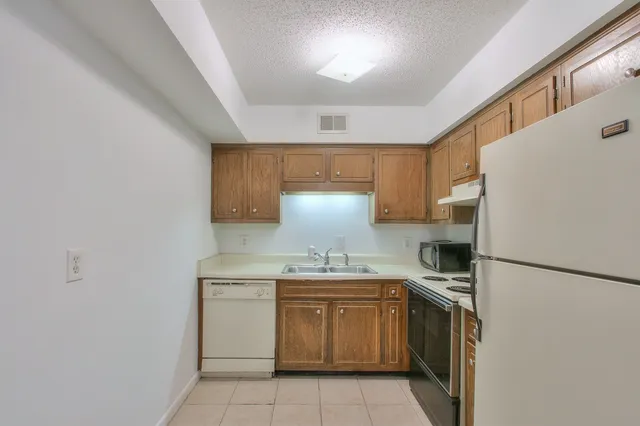 a kitchen with a stove a refrigerator and a sink