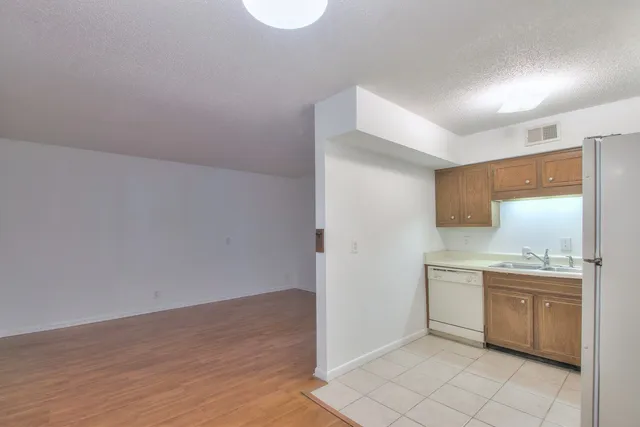 a kitchen with a sink cabinets and wooden floor
