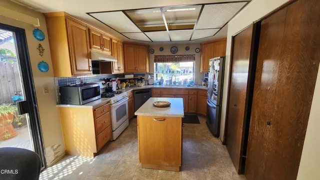 a kitchen that has a sink cabinets counter space and stainless steel appliances