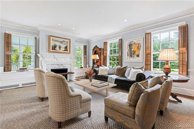 a living room with fireplace furniture and a large window