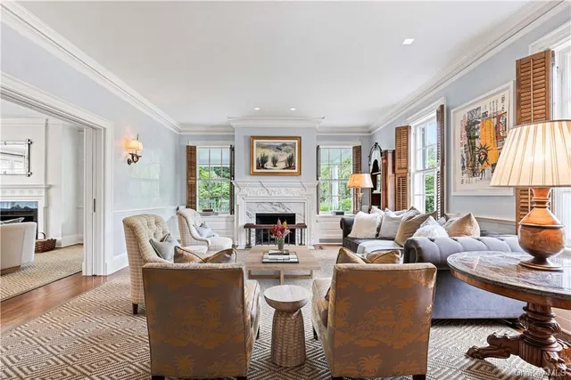 a living room with furniture a fireplace and a chandelier