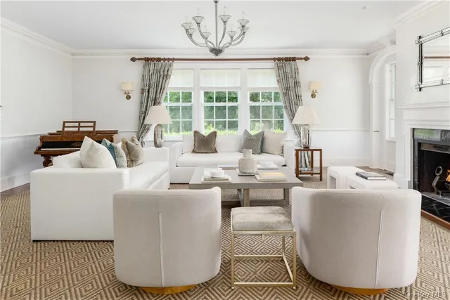 a living room with furniture a fireplace and a large window