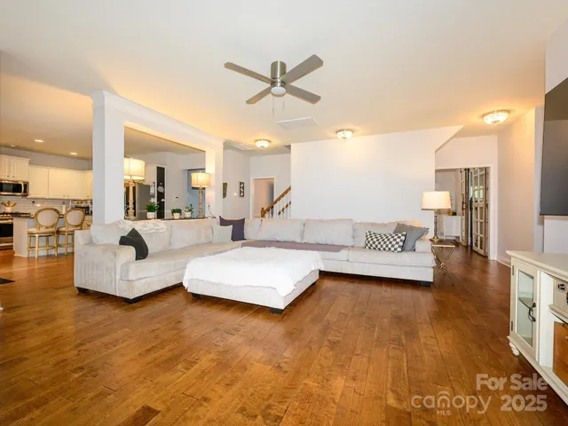 a living room with furniture and a view of kitchen