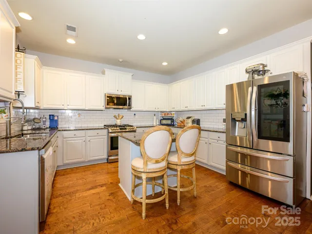 a kitchen with granite countertop appliances cabinets and furniture