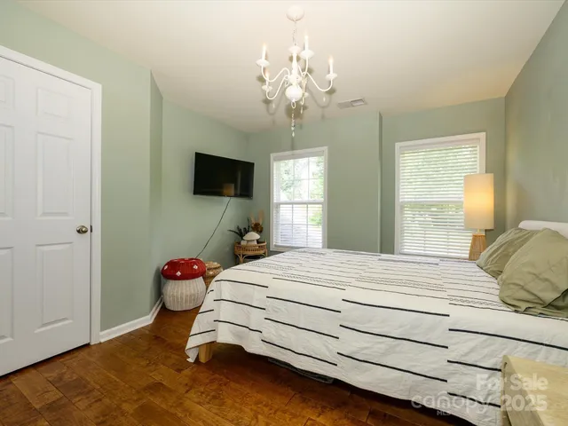 a bedroom with a bed and a chandelier
