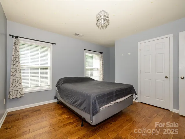 a bed sitting in a spacious bedroom next to a window