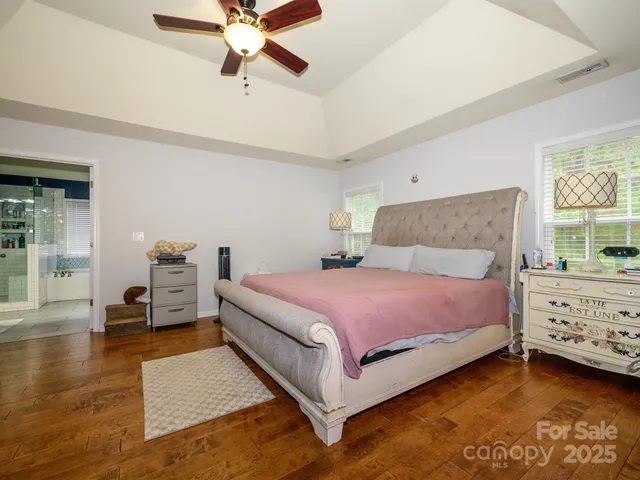 a bedroom with a bed and a chandelier fan