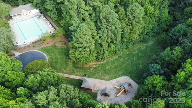 an aerial view of a house with a yard and large trees