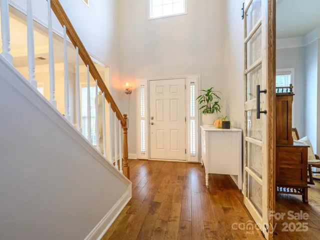 a view of a hallway with wooden floor and staircase