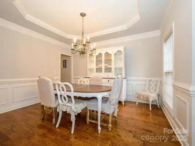 a view of a dining room with furniture wooden floor and chandelier