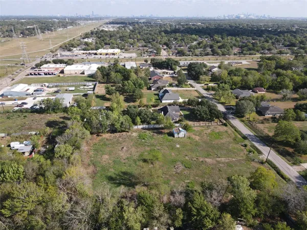 an aerial view of residential houses with outdoor space and trees