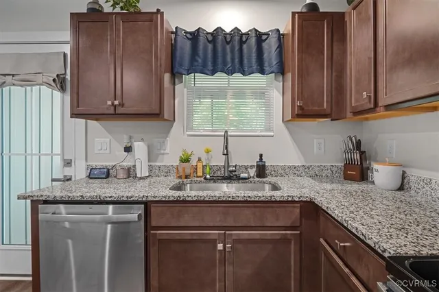 a kitchen with granite countertop wooden cabinets a sink and dishwasher
