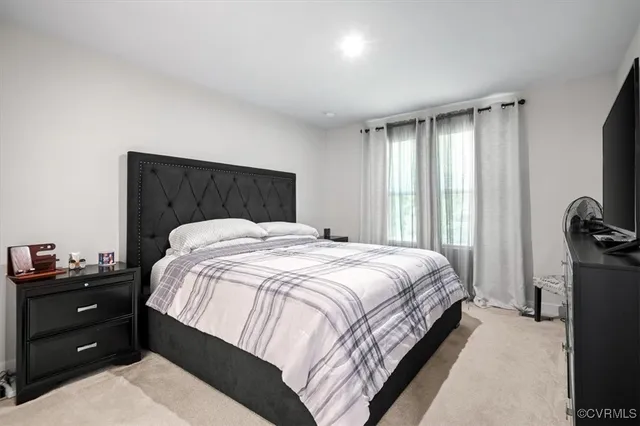 a bedroom with a bed and a tv on the dresser