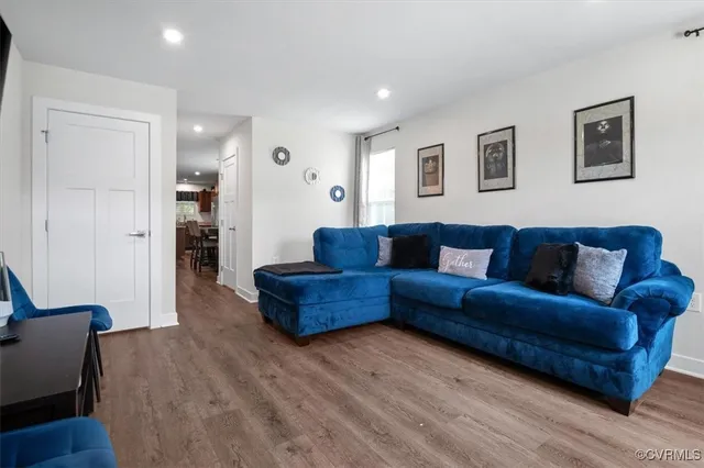 a living room with furniture and a wooden floor
