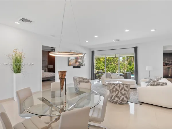 a dining room with furniture a large window and a chandelier