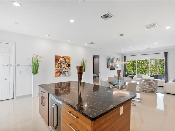 a view of kitchen island a sink a counter top space and living room