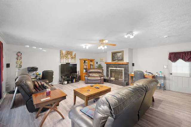 a living room with furniture a flat screen tv and kitchen view