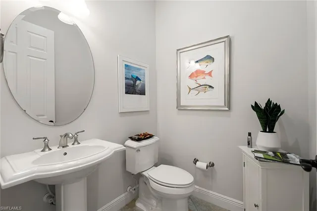 a bathroom with a toilet a sink and mirror