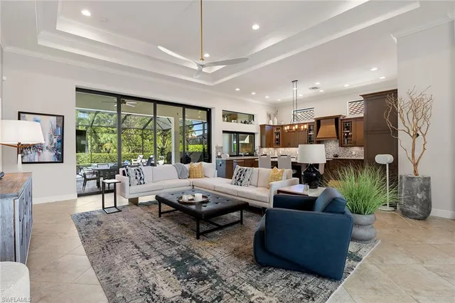 a living room with furniture large window and a dining table