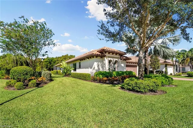 a front view of a house with a yard and potted plants