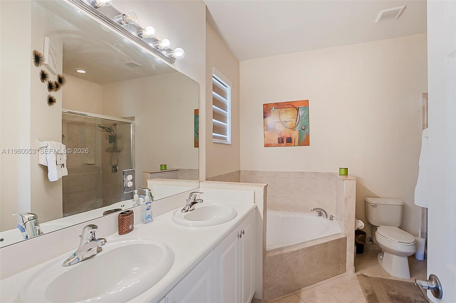 11271 Southwest 234 Terrace Homestead, FL 33032 - Photo 21 of 44 a bathroom with a double vanity sink mirror bathtub and toilet