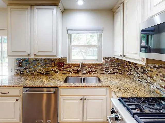 a kitchen with sink stove and cabinets