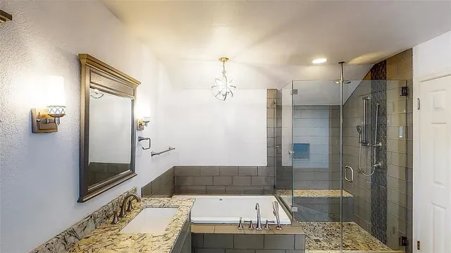 a bathroom with a tub shower and sink