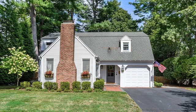 a aerial view of a house next to a yard and large trees