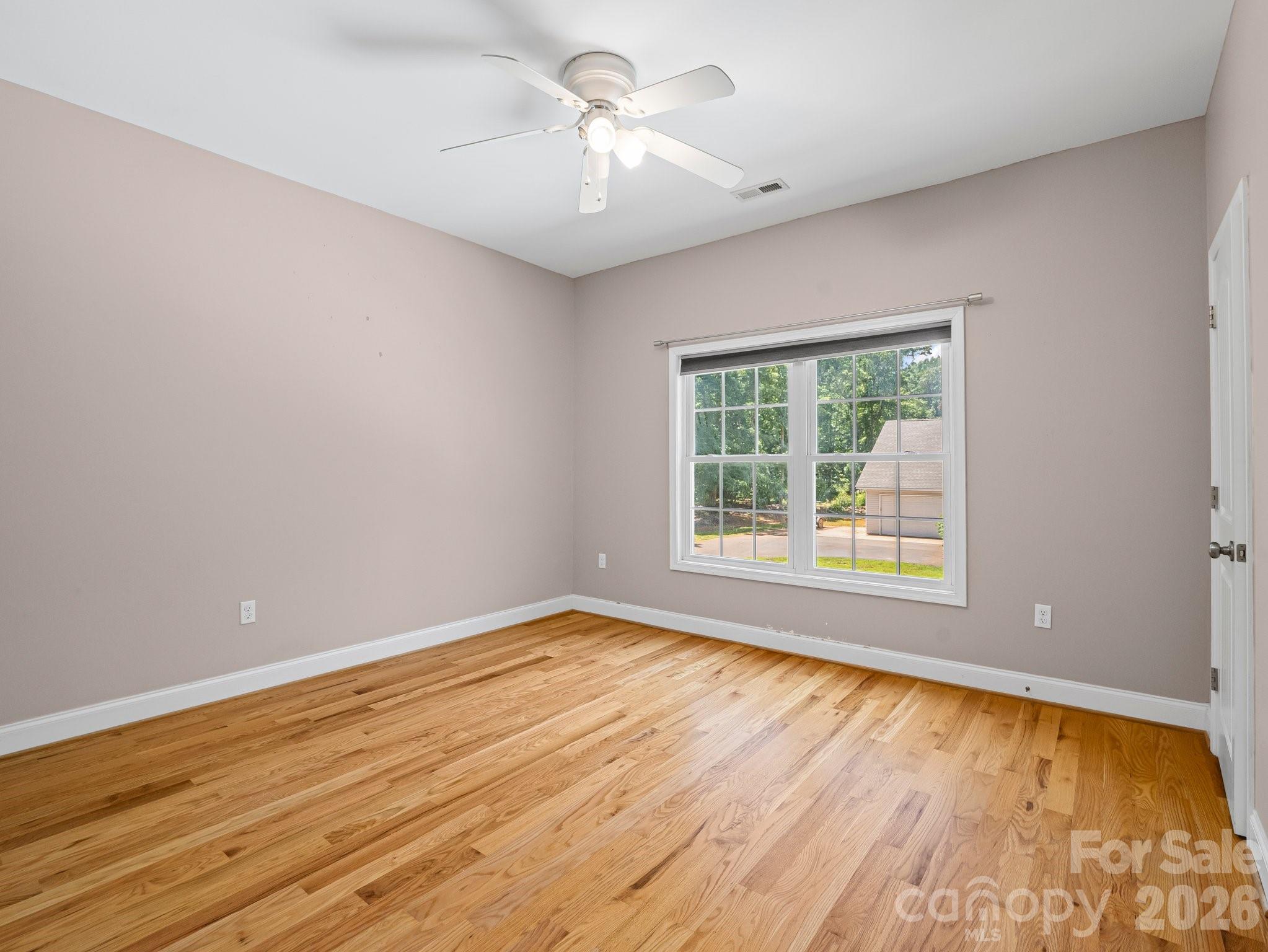 217 Blossom Hill Road Lincolnton, NC 28092 - Photo 39 of 44 a view of empty room with wooden floor and fan