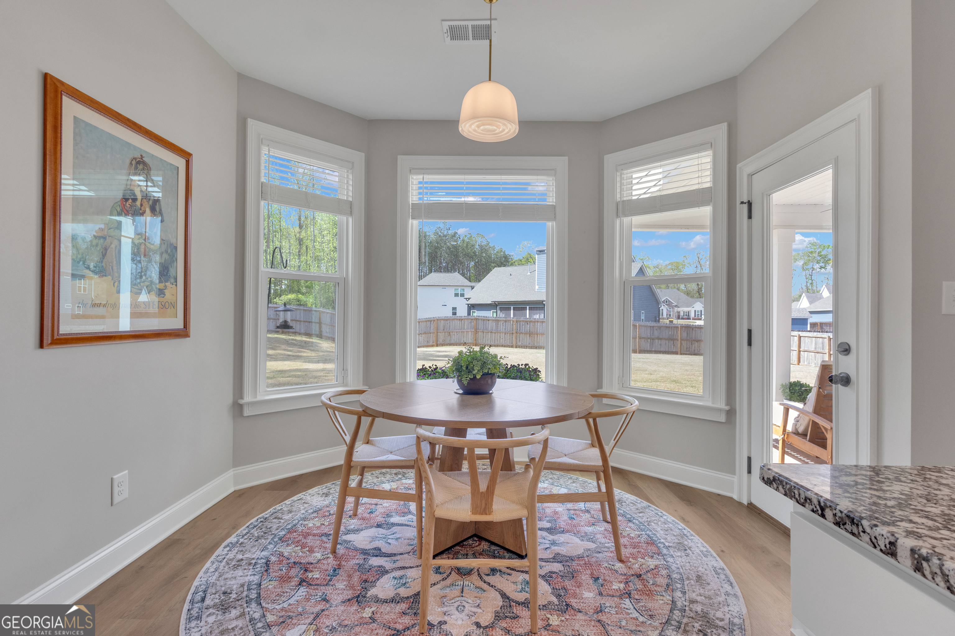 50 Cushing Street Senoia, GA 30276 - Photo 18 of 72 a dining room with wooden floor a chandelier a glass table and chairs