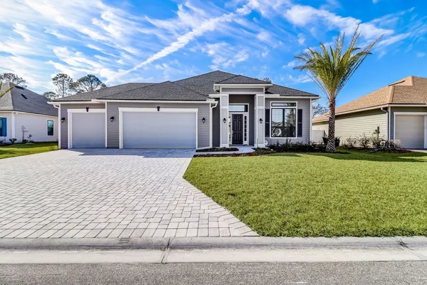 a front view of a house with a yard and garage