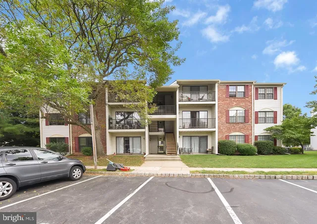 a front view of a residential apartment building with a yard