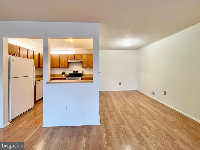 a view of a kitchen with a sink and a refrigerator