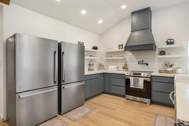 a kitchen with stainless steel appliances granite countertop a refrigerator and a stove